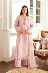 Woman in a pink traditional outfit standing in a well-lit room with decorative elements.
